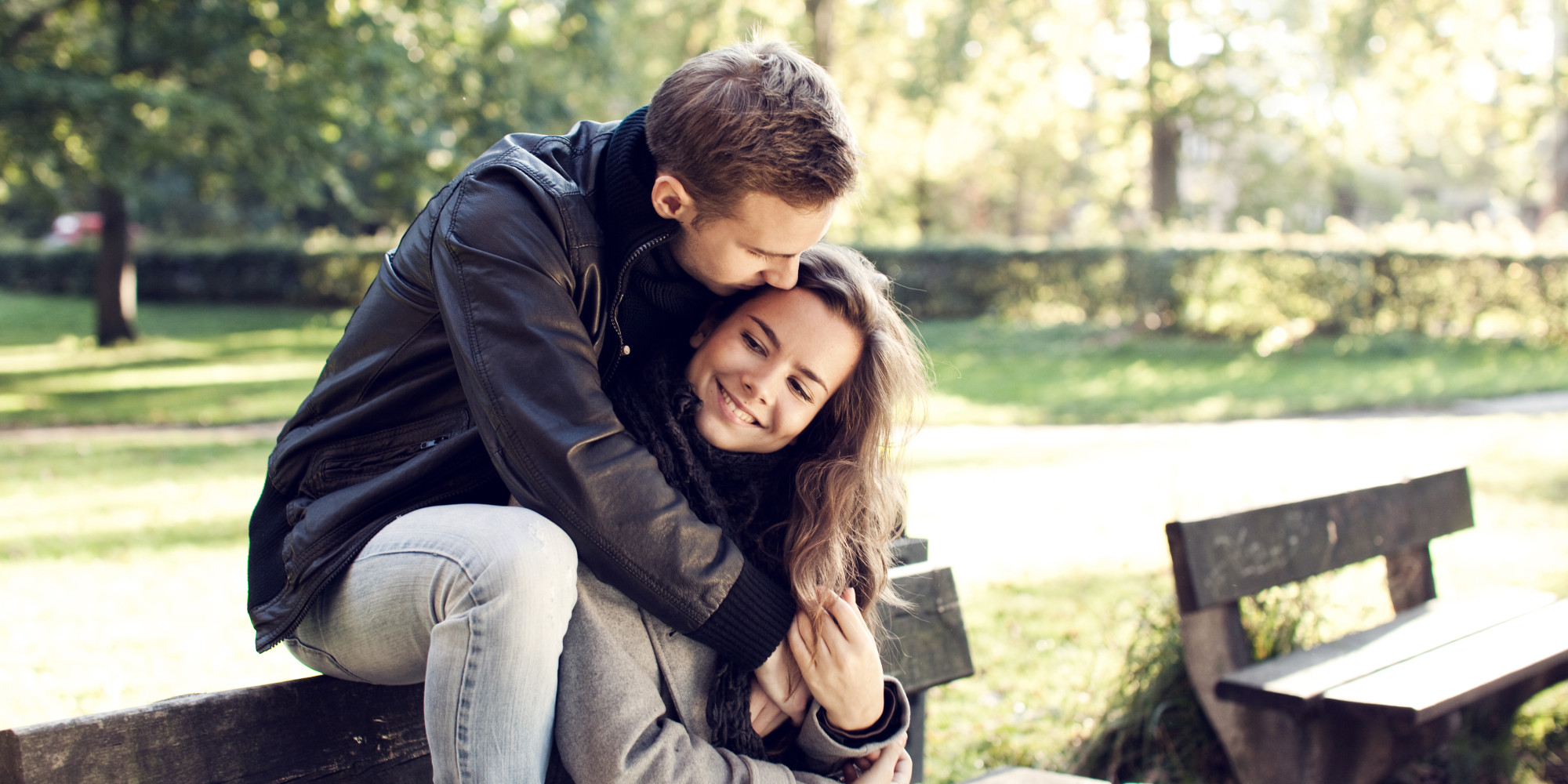 Young couple sitting on bench outdoor. 